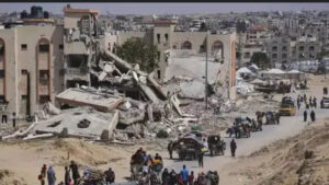 a group of people walking on a road with a collapsed building